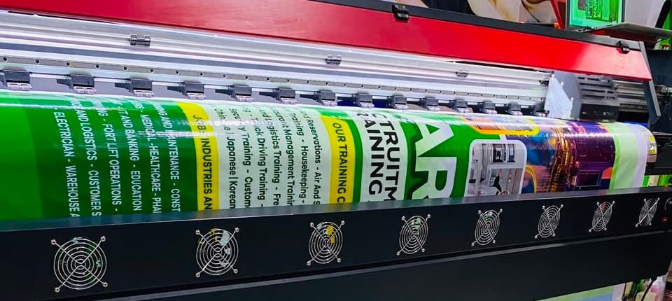 Large-format printer laying down ink on a banner at Oman Gallery's Manso Abore studio